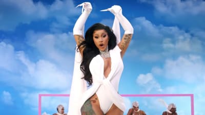 Cardi B i vita kläder med blå himmel som bakgrund, från musikvideon till låten "Up". 