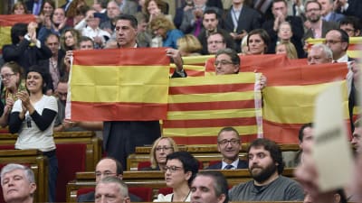 Spanska flaggan lyfts fram efter omröstning i det katalanska parlamentet.