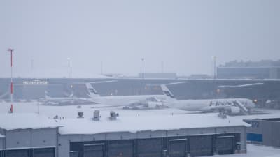 Finnairs flygplan står på en snöig flygplats. 