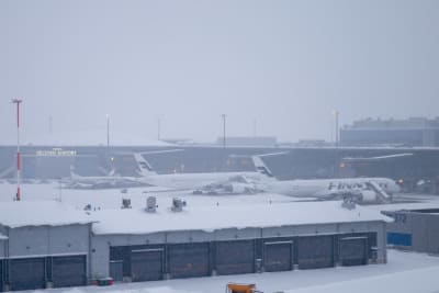 Finnairs flygplan står på en snöig flygplats. 