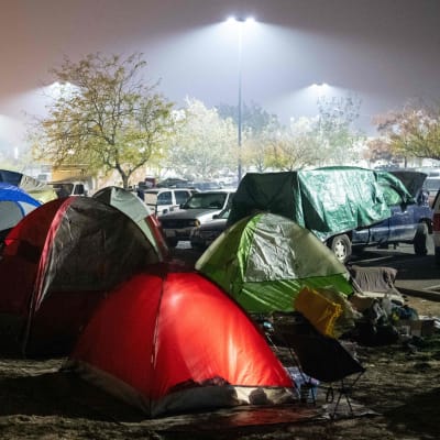 Nattlig bild av tältby på en parkeringsplats i Chico efter kaliforniska skogbranden.