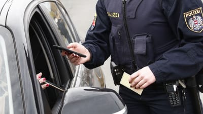 Österrike. En polis kontrollerar covidintyg av en bilist.