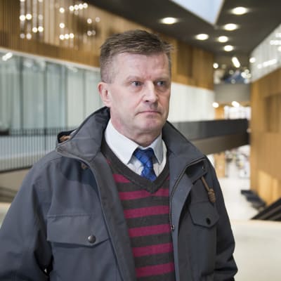En man med kort brunt hår ser bister ut.