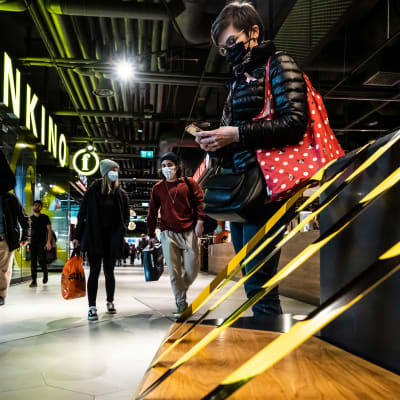 Kauppakeskuksessa ihmisiä suojautuneena kasvomaskeihin.