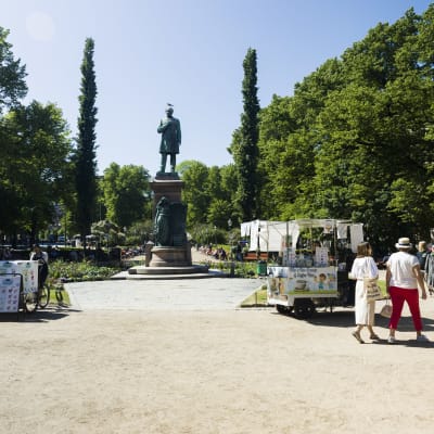 Esplanadparken sommartid med Johan Ludvig Runeberg-statyn i mitten, omgiven av gröna träd.
