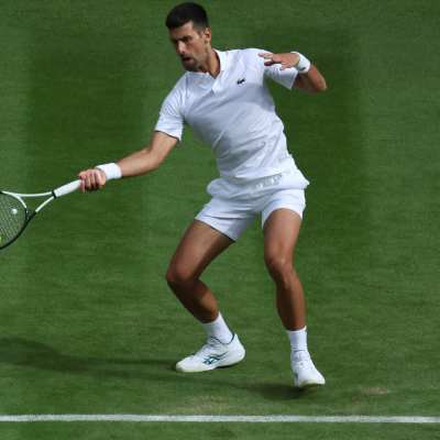 Tennisspelaren Novak Djokovic slår en forehand på gräs.