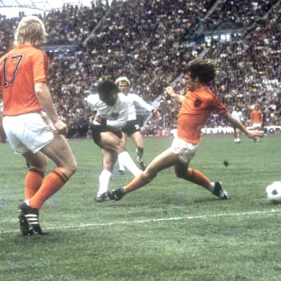 Tysk skjuter boll mellan holländskt försvar 1974