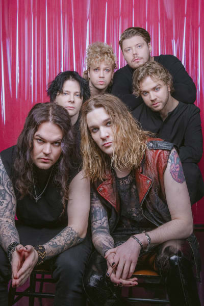 Blind Channelin jäsenet pinkkiä taustaa vasten.