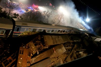 Ett tåg som spårat ur krockat med ett annat. Rök stiger från tågen.
