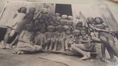 "Internerade barn på andra barackens trappa sommaren 1945"  Ett svartvitt foto