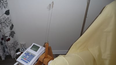 apparaten som mäter frekvenser. En låda med siffror och en stav med metallfjäder formad som spiral i toppen.