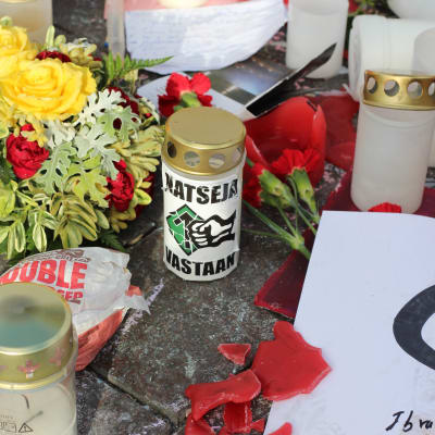 Blommor och ljus vid den plats där en person misshandlades till döds i Helsingfors.