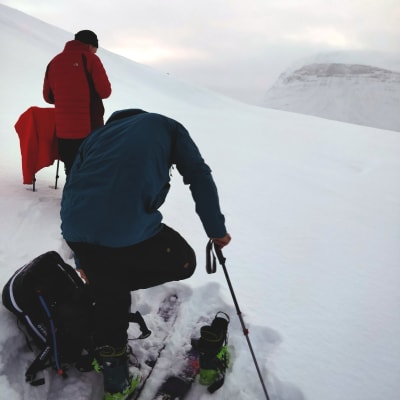 Två skidåkare på ett fjäll i Matokdalen, bakom molnen finns Blåbærfjellet.