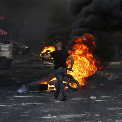 Man bränner däck på gata i Jenin.