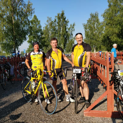 Tre tävlingscyklister som poserar med sina cyklar.