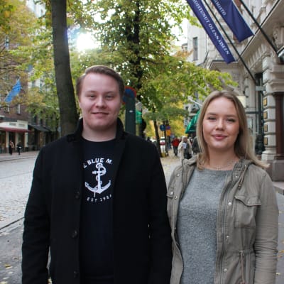 Ålänningarna Emil Rönnberg och Emma Lindvall tittar in i kameran. Ungdomarna står i centrala Helsingfors. 