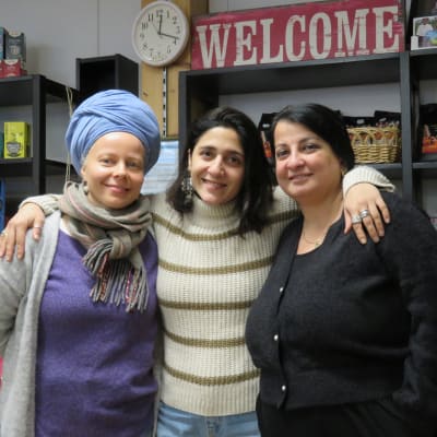 Tre kvinnor, Maarit Kinnunen, Carmen Gheorghe och Anca Nica står och håller om varandra i Emmaus affär och loppis i Ekenäs.