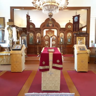 Rött och guld dominerar interiören i Hangö ortodoxa kyrka. Kyrkoväggarna är vita.