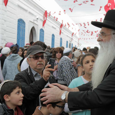 En rabbin på besök från Israel välsignar barn från Djerba.