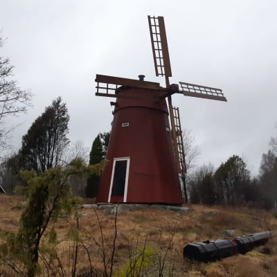 En röd väderkvarn på ett berg i Ingå.