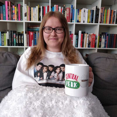Vänner-fanet Linnéa Holmberg i Vänner-tröja och med en Central Perk-kopp i handen. 