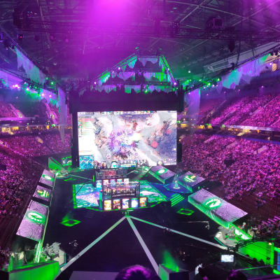 En arena fylld med folk. I mitten syns stora skärmar som visar dataspelet Dota 2. Det är en turnering i spelet på gång i arenan.