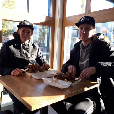 Två ungdomar sitter och äter kebab vid en kebabrestaurang på Brändö i Vasa.
