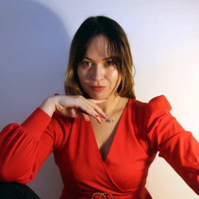 Författaren Julia Mäkkylä i röd blus.