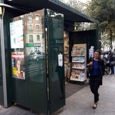 En person går förbi en tidningskiosk i Frankrike.