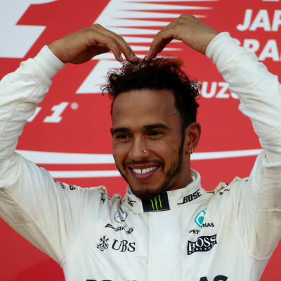Lewis Hamilton står på prispallen.