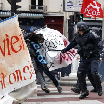 Poliisi otta yhteen mielenosoittajien kanssa Pariisissa, ranskankielisiä banderolleja