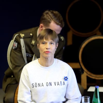 Kersti Kaljulaid i det estniska parlamentet i en vit tröja med texten Sona on vaba. 