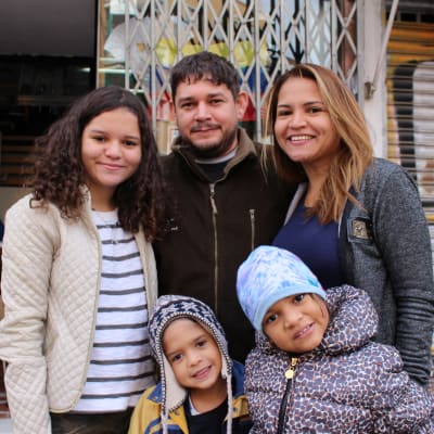 På bilden ser vi familjen Bellomo som precis har anlänt till Venezuela. På bilden ser vi fempersonersfamiljen i nya vinterkläder de fått av en frivilligorganisation.