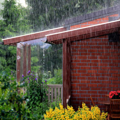 Häftig regnskur sköljer radhusterass.
