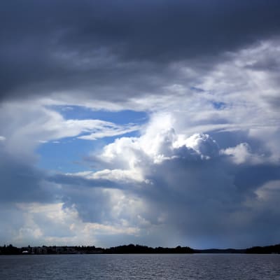 Molnhimmel över sjö.