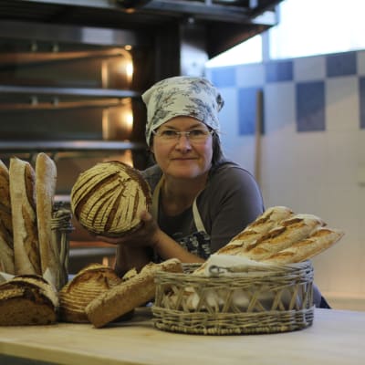 Johanna Hasu från bageriet Leipä ja poika står vid disken med bröd bredvid sig.