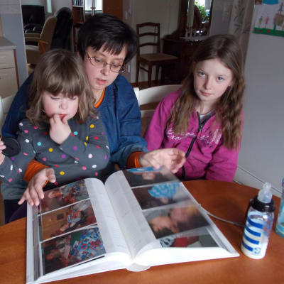 Camilla Palén tillsammans med döttrarna Sissel och Sandra tittar på bilder av sonen och brodern Hannes som dog endast fem år gammal.