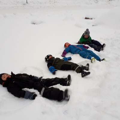 Barn leker i snön.