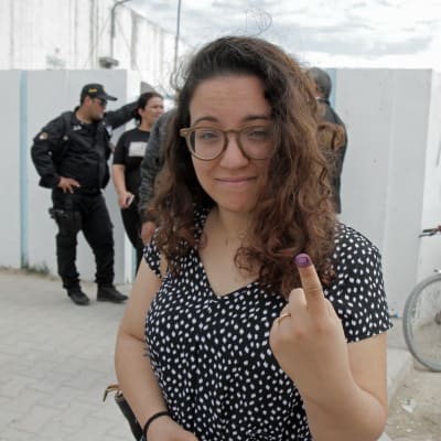 Väljare i Tunis visar sitt finger som markerats med bläck som bevis på att hon röstat i lokalvalet.