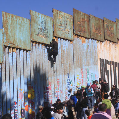 Ett tiotal centralamerikaner som klättrade över stängslet, greps genast av amerikanska gränsvakter