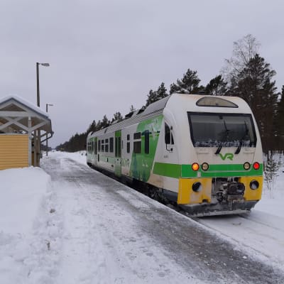 En grönvit rälsbuss på järnvägsspåret i Skogby.