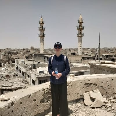 Mariette Hägglund i Mosul, Irak. I bakgrunden syns hus i ruiner.