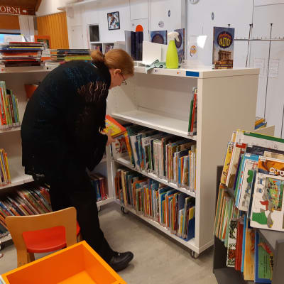 Barnbibliotekarie Rebecka Asikainen i ordnar böcker i Ekenäs bibliotek.