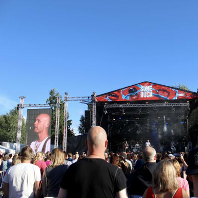 Juha Tapio esiintyy Simerockin lavalla, yleisöä on lavan edessä.