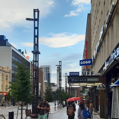Trottoar i centrum av Tammerfors med fotgängare och Danske Banks skylt 