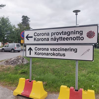 Skyltar som det står corona provtagning och corona vaccinering på.