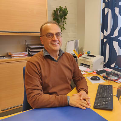 Man sitter vid sitt skrivbord på ett kontor.