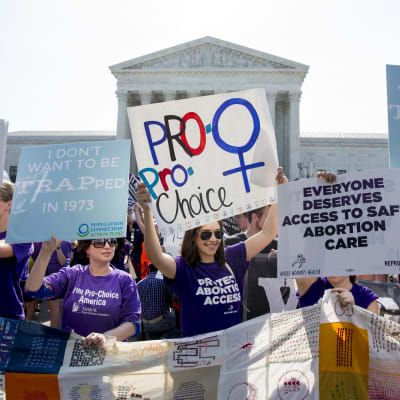 Aborttioikeutta kannattavat mielenosoittajat pitävät käsissään plakaatteja Washingtonin korkeimman oikeuden rakennuksen edustajalla.