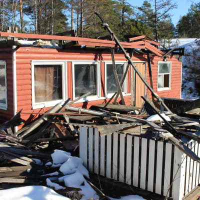 en kiosk som brunnit och bråta framför
