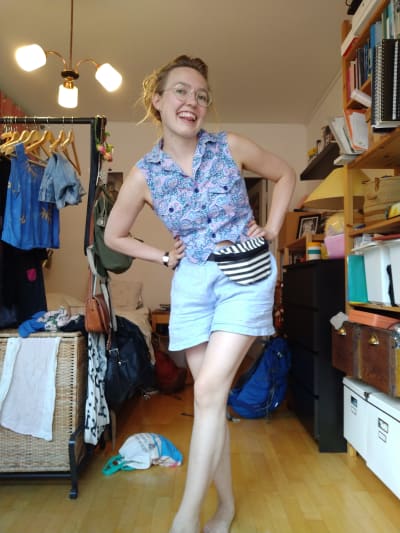 ung kvinna poserar i shorts och linne